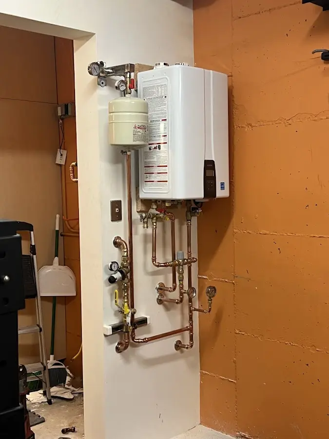 Plumbing technician inspecting water heater connections in Somerton